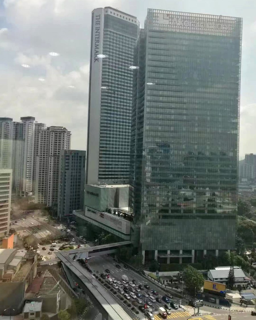 吉隆坡市中心的高楼与高架路车流，左侧塔楼立面上可见 THE INTERMARK 字样