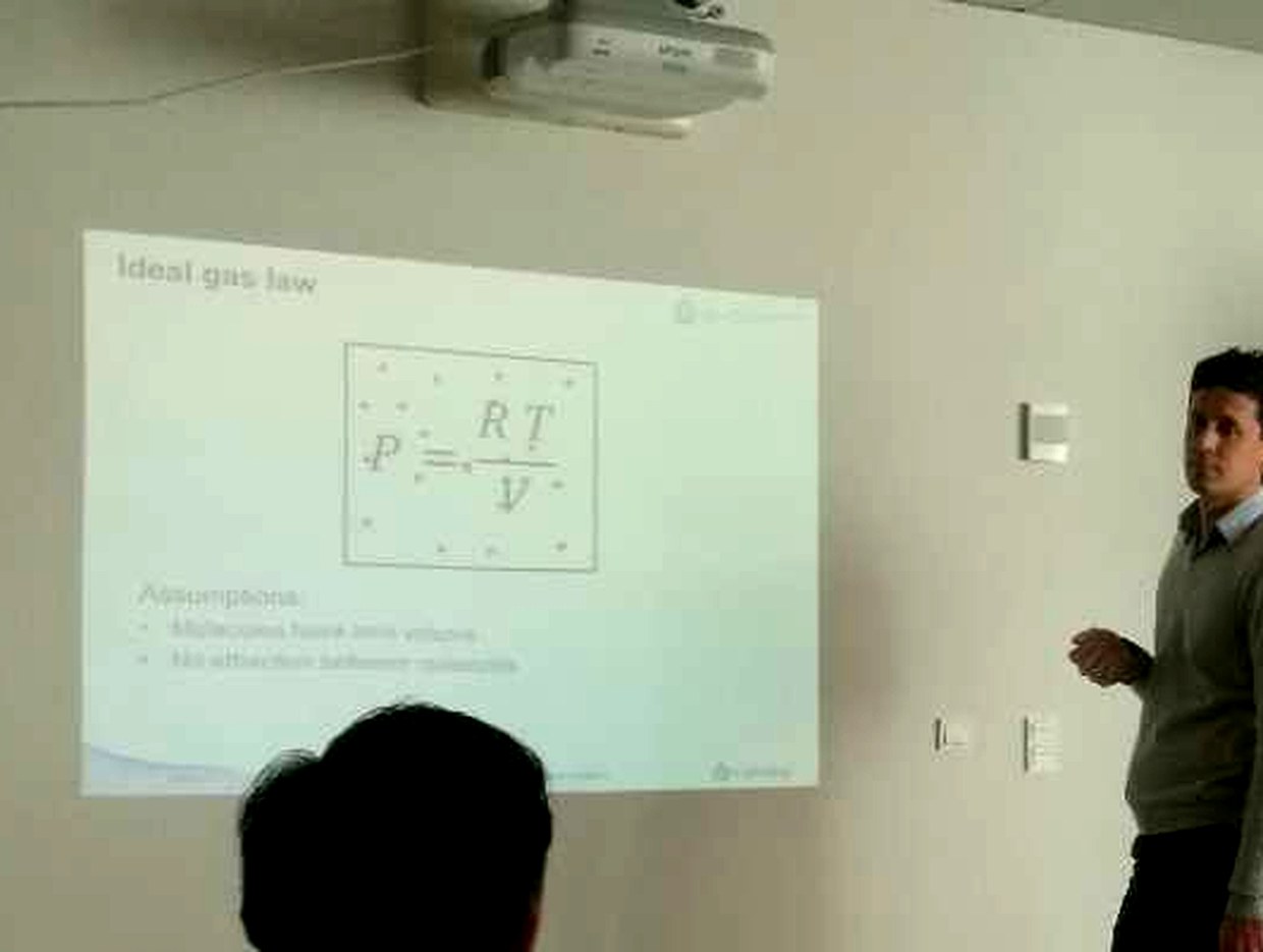 投影幕布上的课件第一页，标题为 Ideal gas law，公式框内为 p 等于 RT 除以 V，下方列出两条 Assumptions