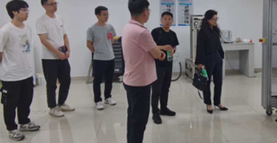 参观人员一行在实验中心内听取讲解并进行交流