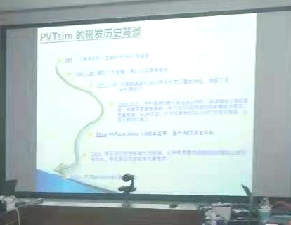 投影幕布上的「PVTsim 的研发历史背景」一页，以时间轴形式排列各阶段节点